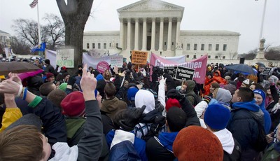 
              FILE - In this Jan. 23, 2012 file photo, anti-abortion and abortion rights supporters stand face to face in front of the Supreme Court in Washington, Monday, Jan. 23, 2012, during the a